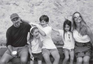 Steve Jobs con moglie e tre figli seduti su una panchina