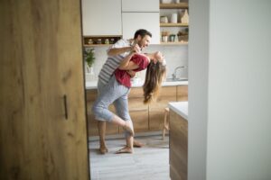 Una giovane coppia balla scalza in cucina durante il lockdown