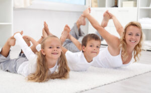 Una mamma passa il tempo con i bambini facendo ginnastica con loro in casa in famiglia in pandemia