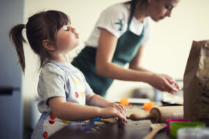 Una mamma con la sua bambina passano tempo assieme cucinando in pandemia